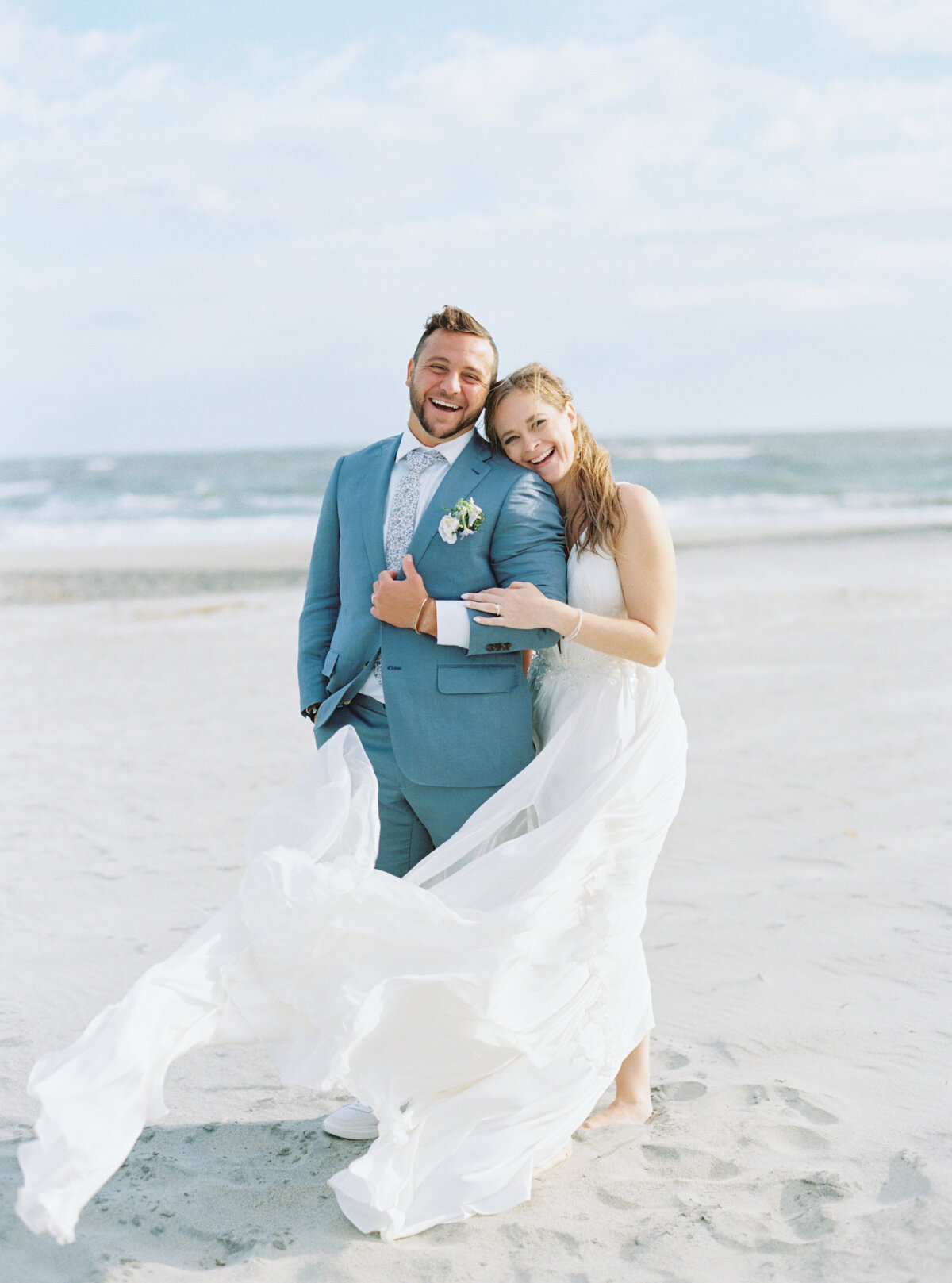 Charleston fall destination wedding. Bride and groom laughing on the beach.