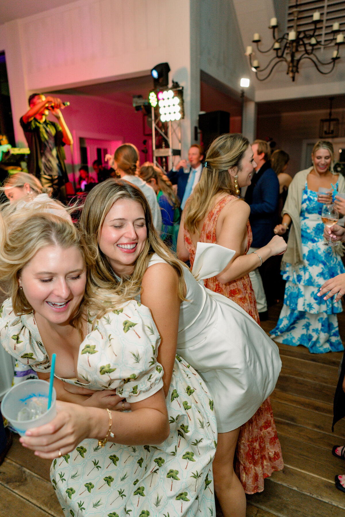 Bride hugs her friend on the dance floor during wedding reception at the River Course Kiawah Island.