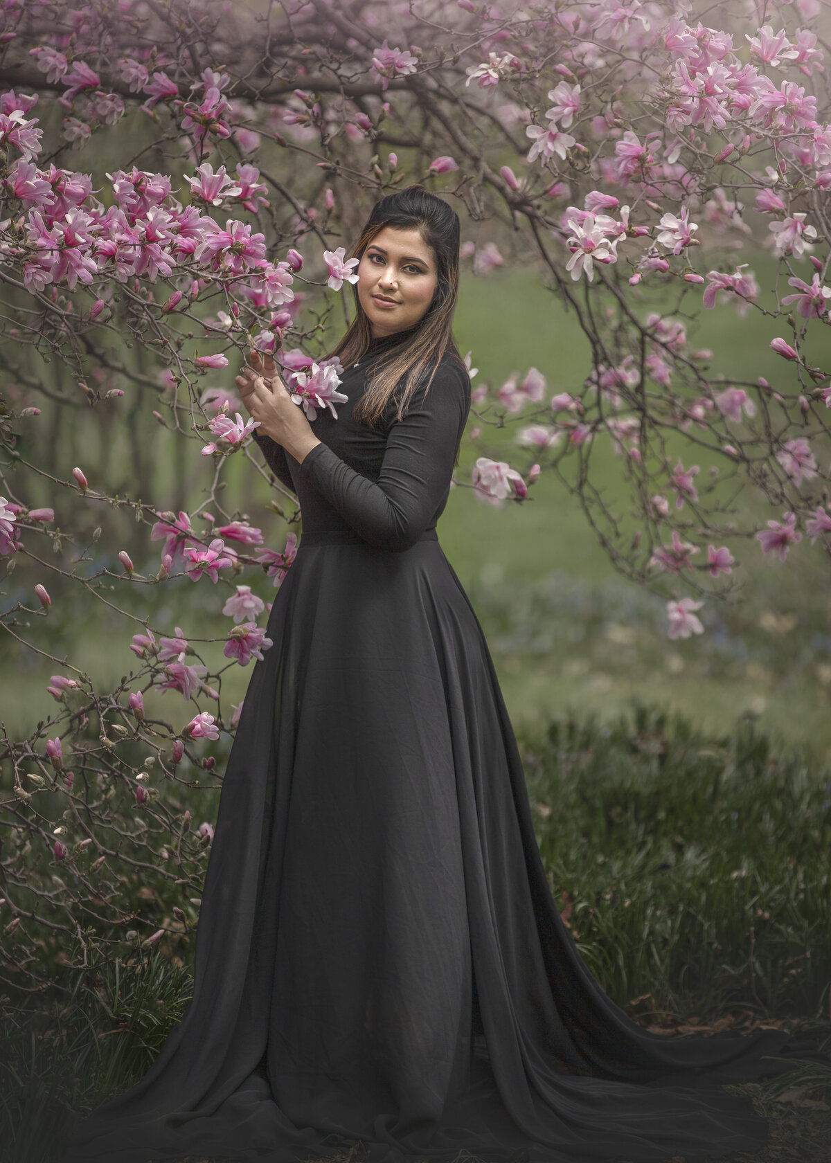 girl in long black dress in the magnolias during her outdoor photography session in Ottawa Ontario