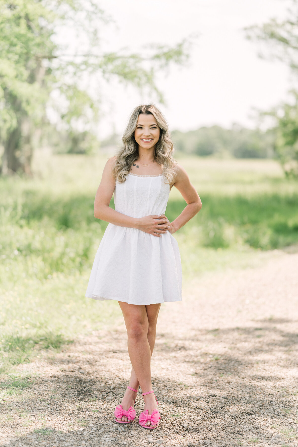 College graduate in pink shoes poses on a trail in Baton Rouge with Morgan Leigh Photography.