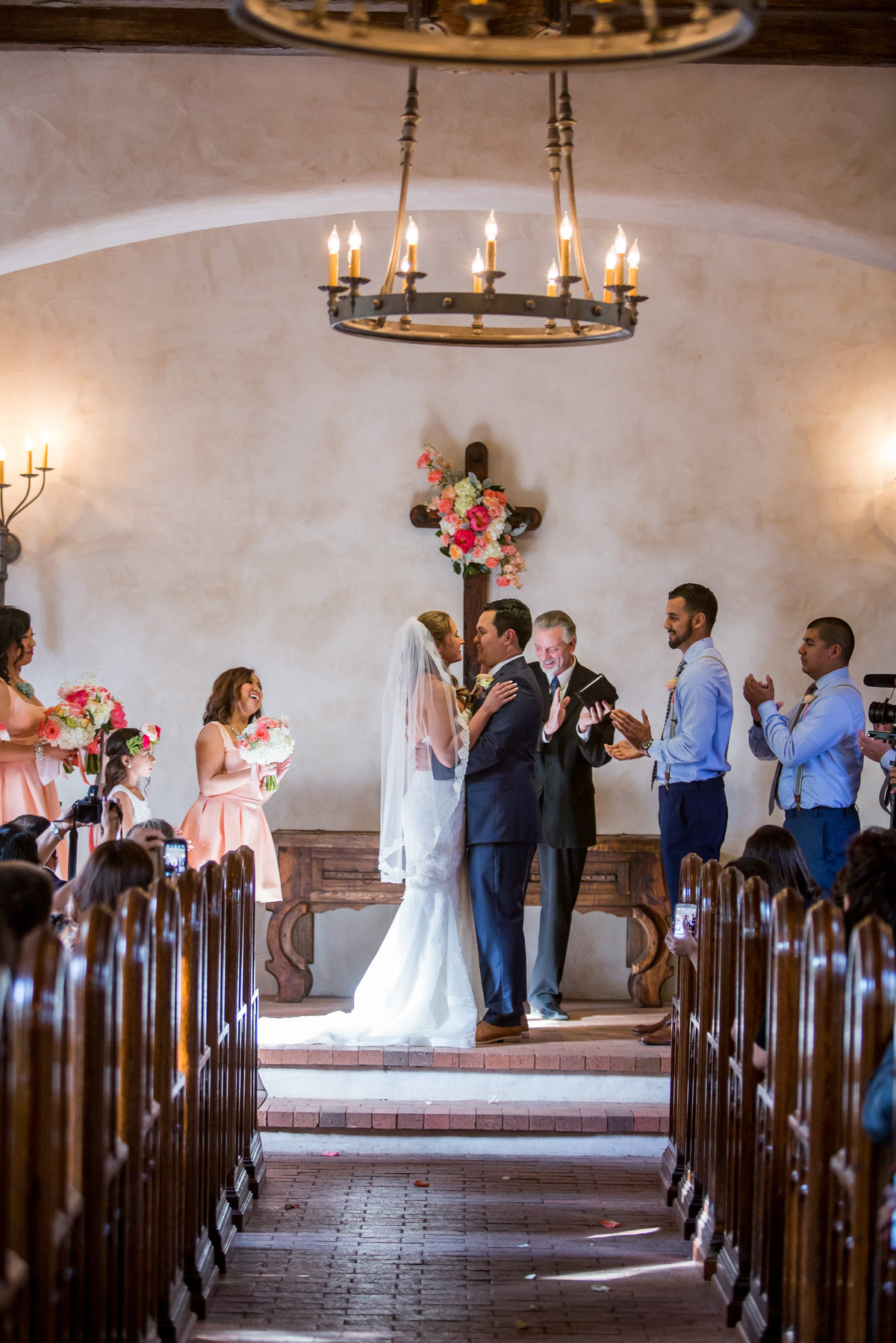 Bride and groom hold each other during wedding ceremony at Lost Mission venue in Hill Country