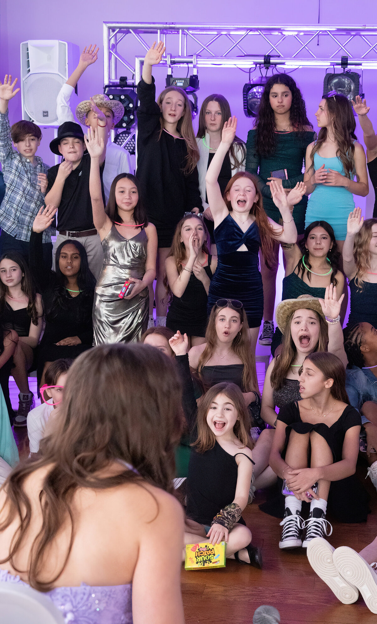 A crow of teenage girls cheers during trivia Old Tappan Manor bat mitzvah Bergen County bar photographer Milestone Images