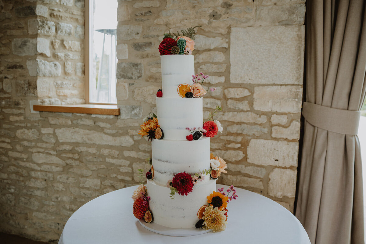 Semi-naked cake with lots of fresh flowers in autumn colours