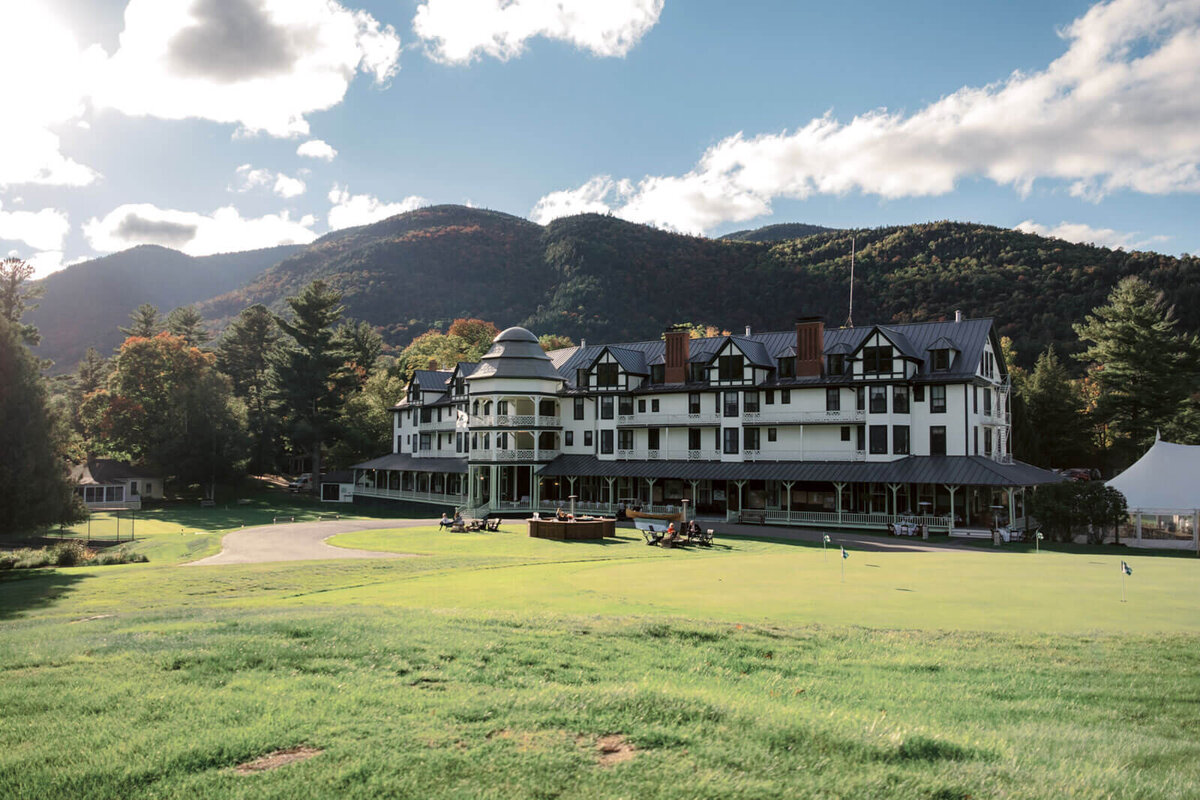 Front view of The Ausable Club, Keene Valley, New York. Trees and mountains are in the background.