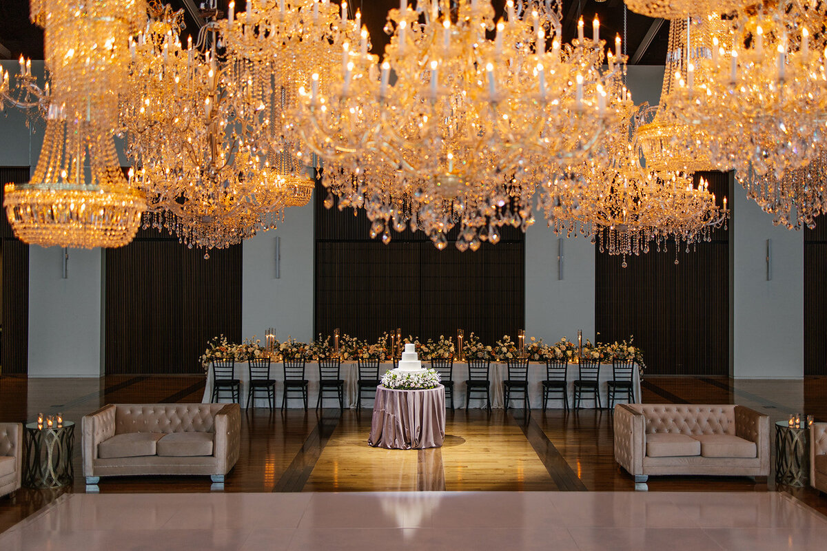 silver and gold crystal chandeliers hanging over white dance floor