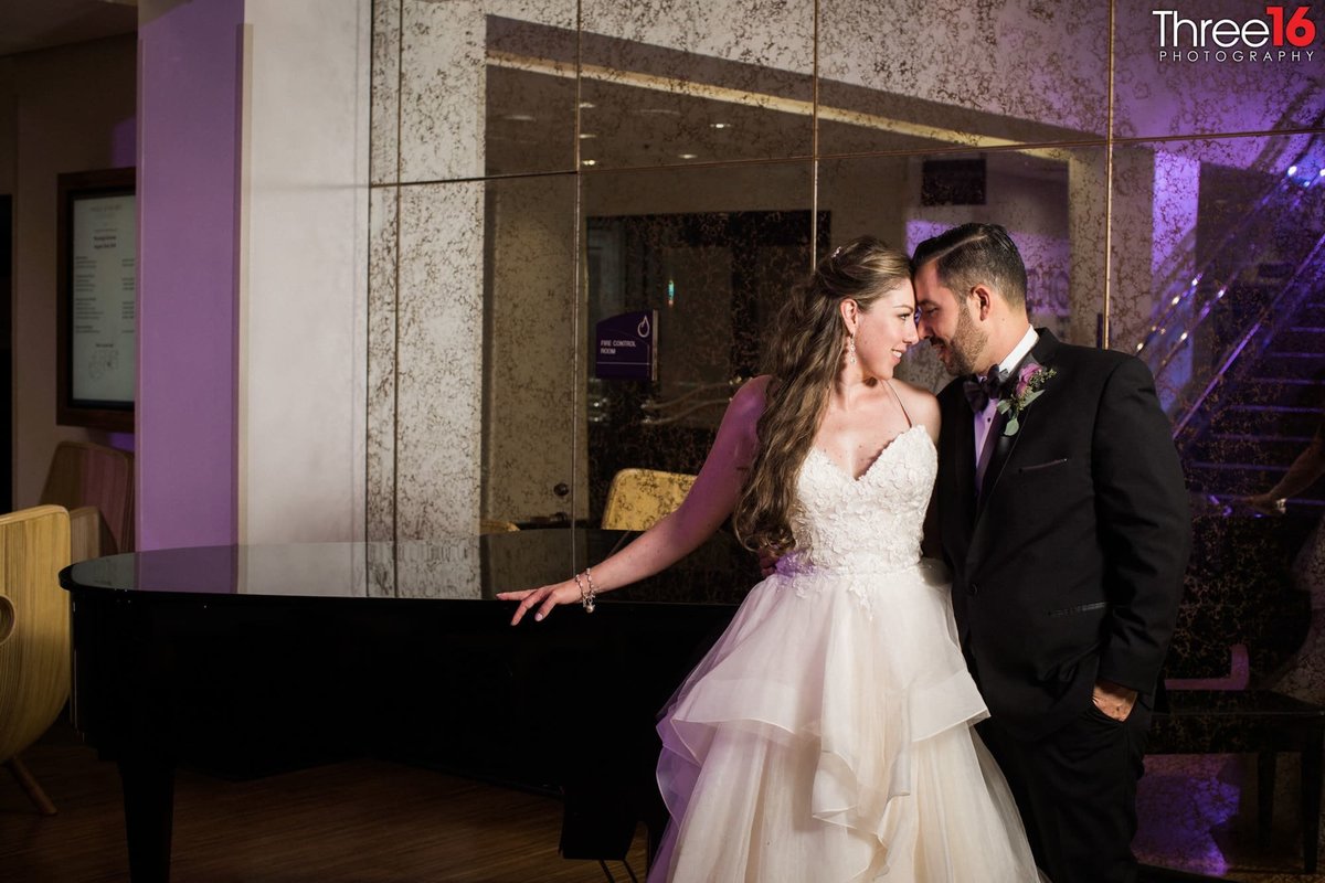 Bride and Groom share a tender moment alone next to grand piano