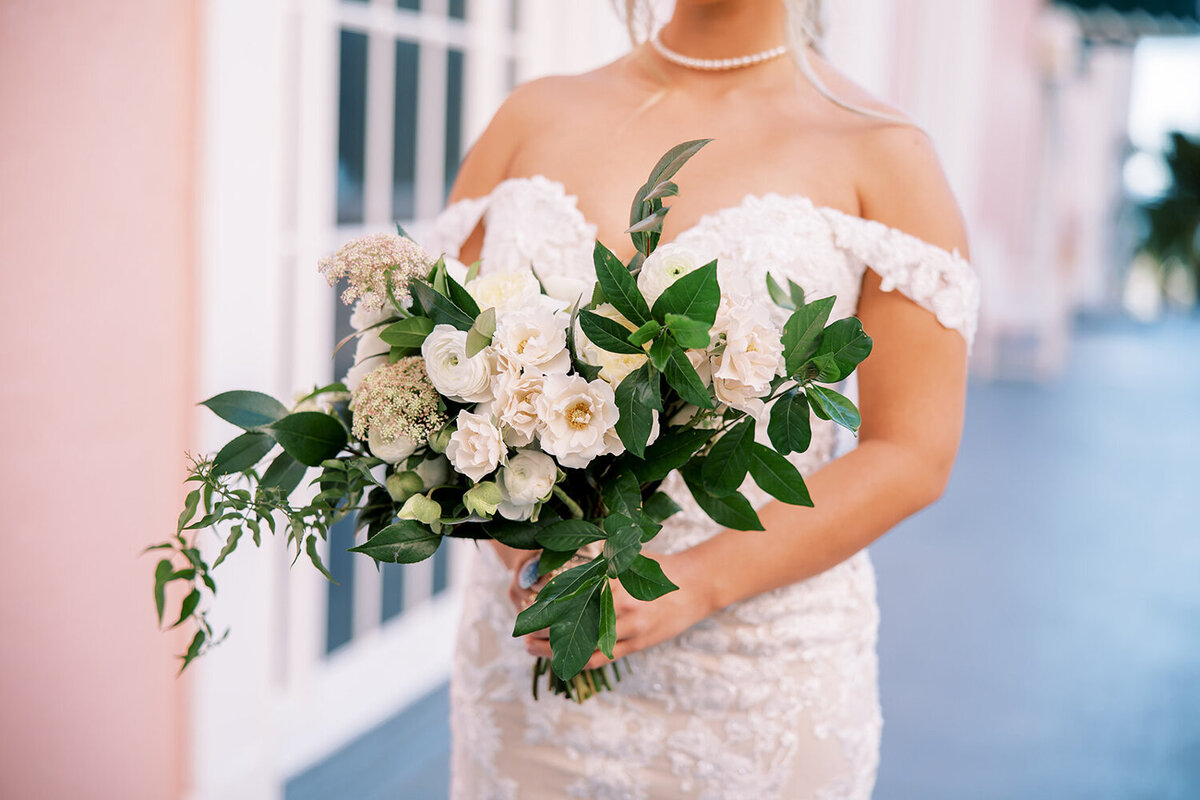 Bridal bouquet of all white flowers held by a bride in a lace dress with drop shoulder straps at her December wedding at the Don Cesar Hotel, St. Pete Beach, FL.