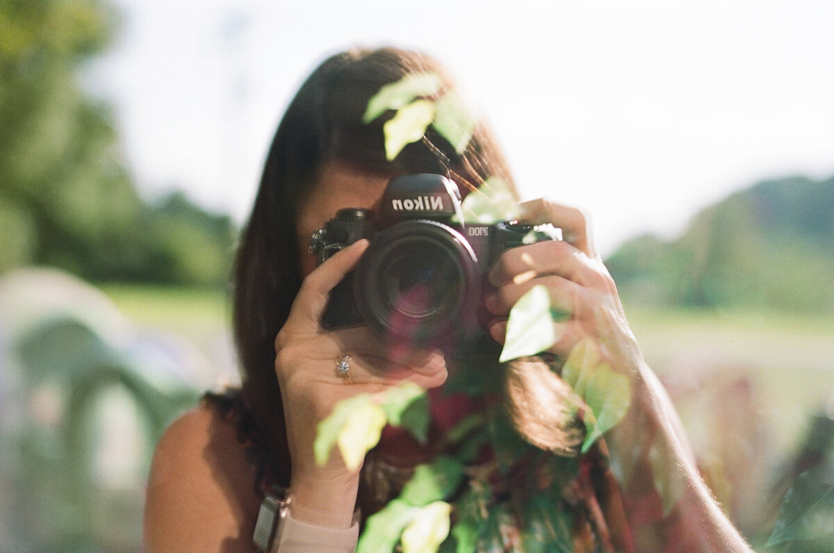 film images of photographer with reflection of leaves in front
