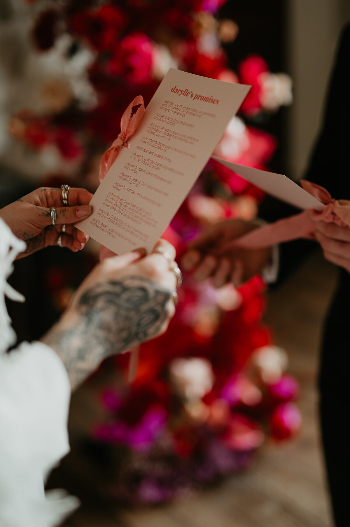 A couple share promises, a tattooed bride holds a card with her promises to her husband.