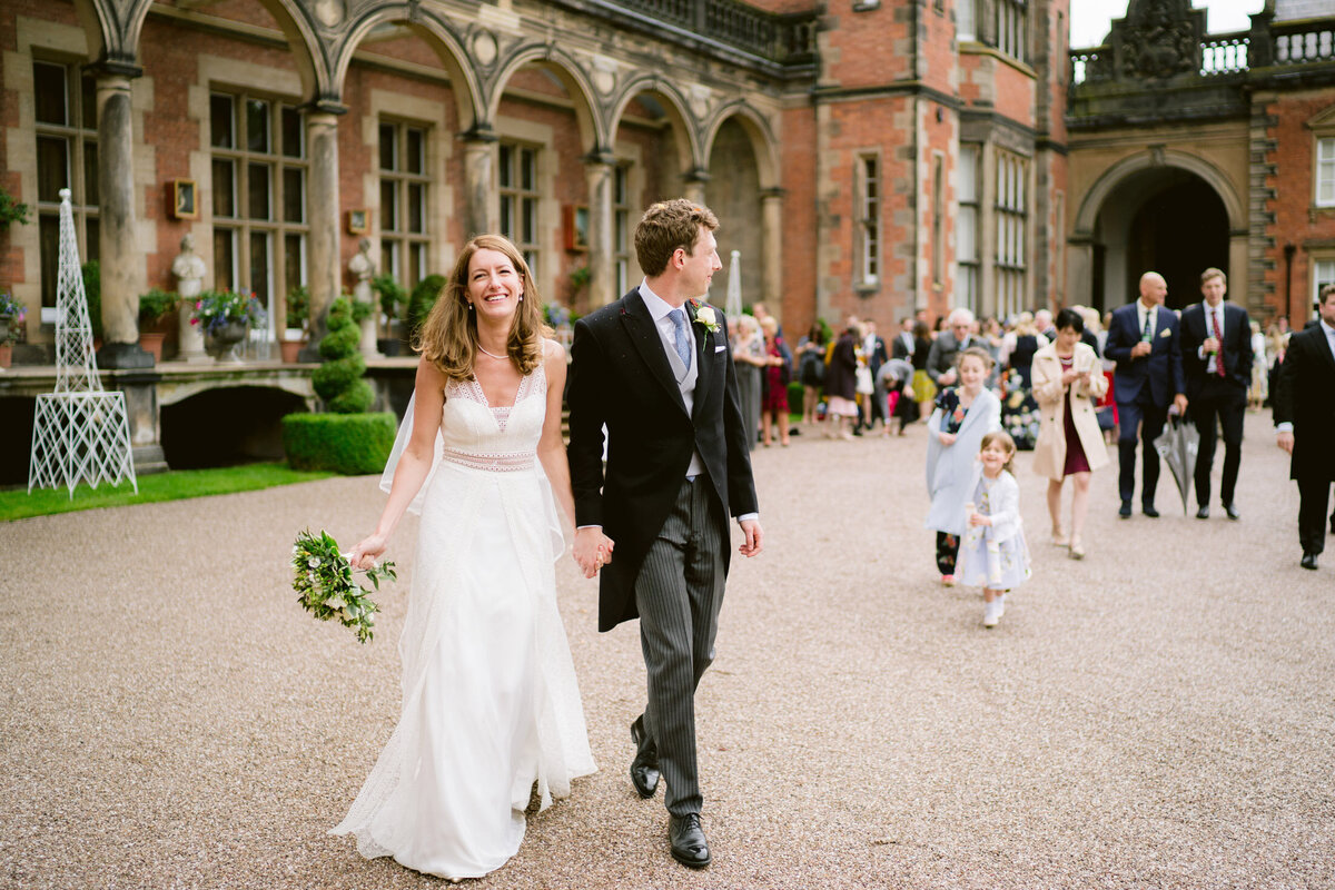 bride and groom leading their wedding guests to the reception at capesthorne hall