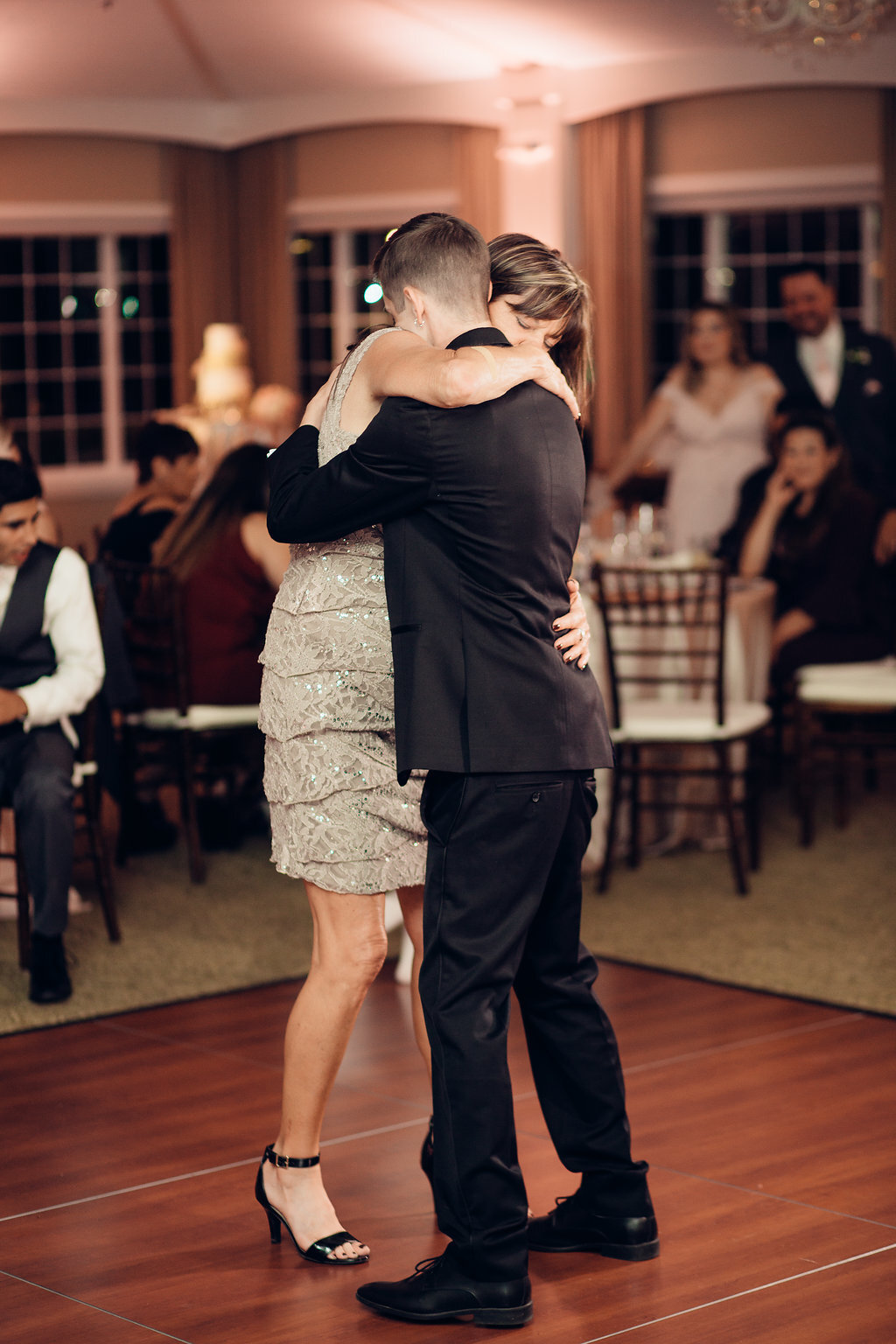 Wedding Photograph Of Groom In Black Suit And Woman In Light Brown Dress Hugging Each Other Los Angeles