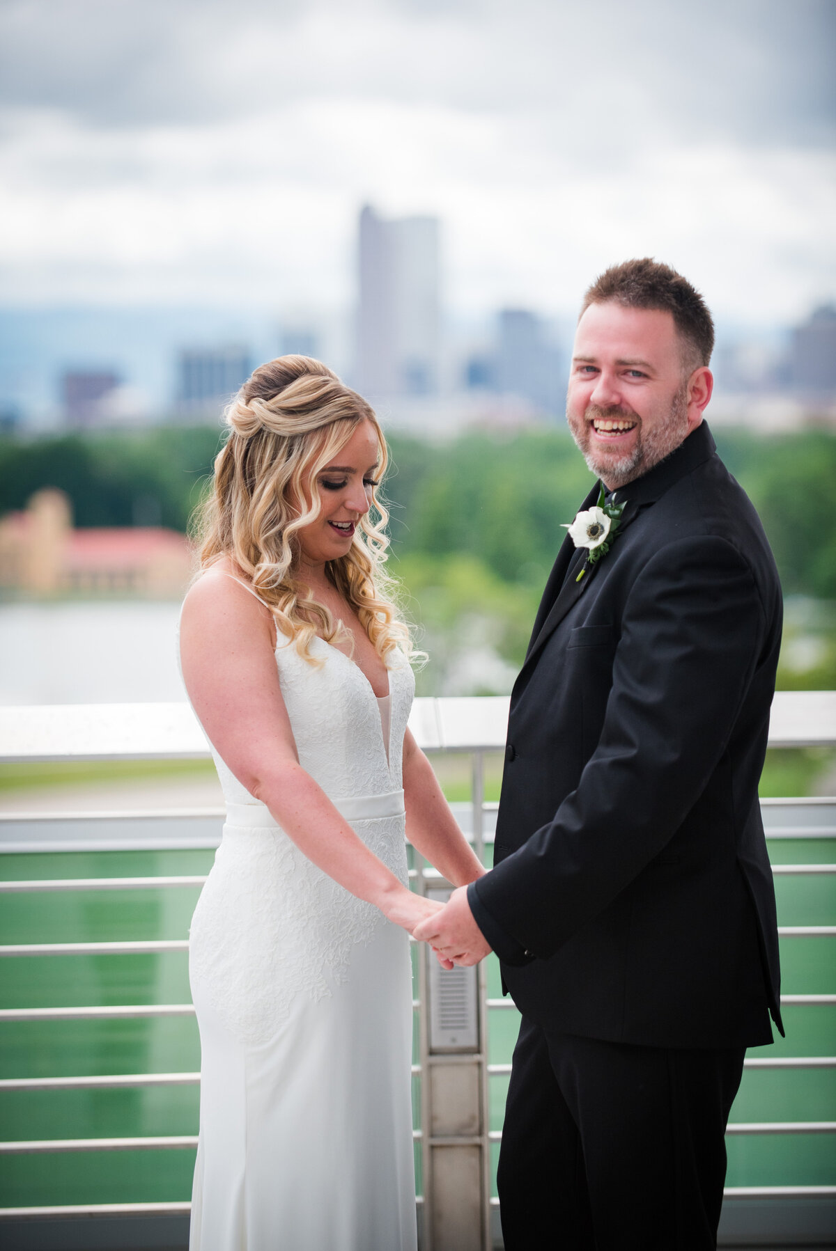 A bride and groom hold hands on the rooftop of the Denver Museum of Nature and Science.