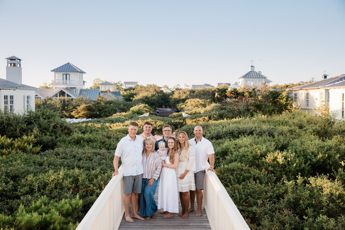 A family standing on a path with green plants on either side of them