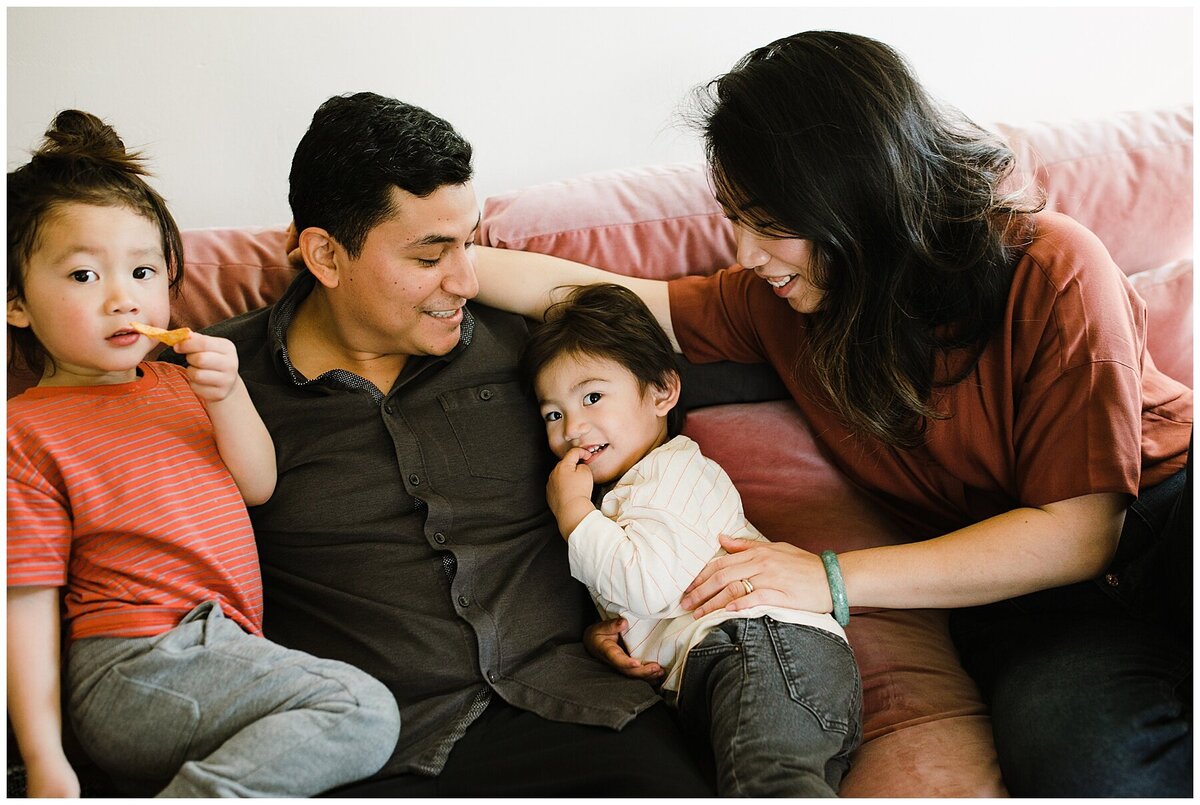 Family of four sitting on sofa at family photo session in Austin by Amber Vickey Photography