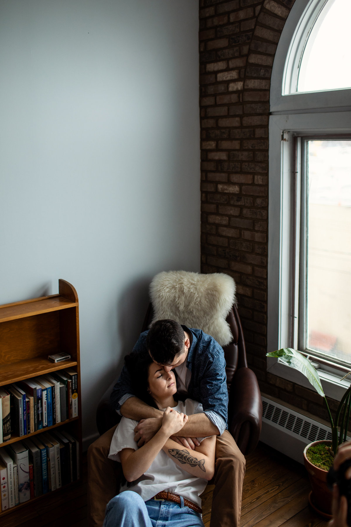lifestyle session with couple cuddling at home by a window