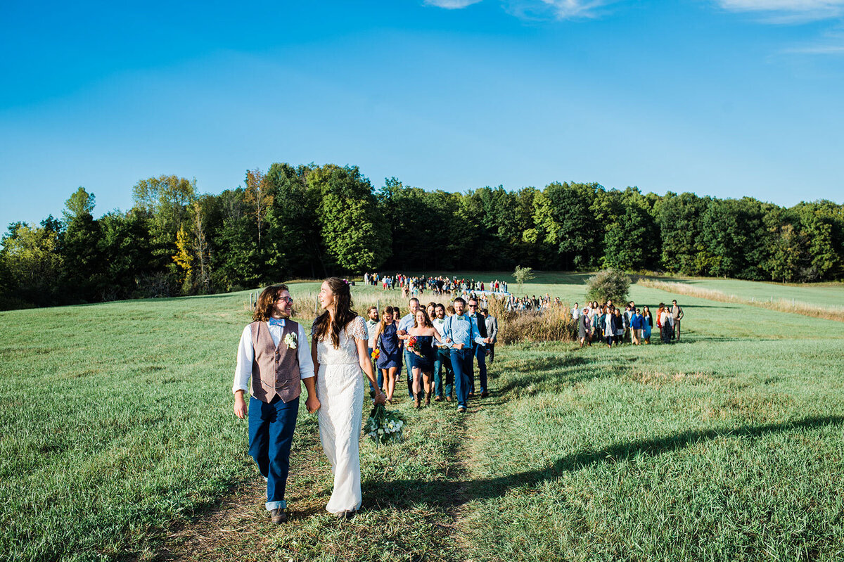 bride and groom leading guests at vermont farm wedding south hero lake champlain