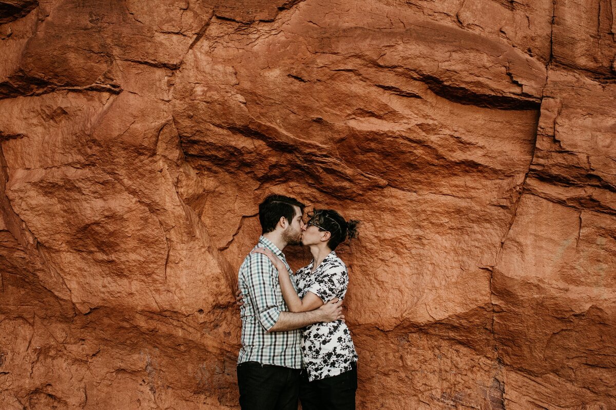 gay couple kissing in front of red rocks