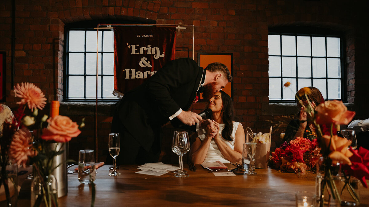 Groom kisses his bride during his speech at his wedding at The Stables in Manchester.
