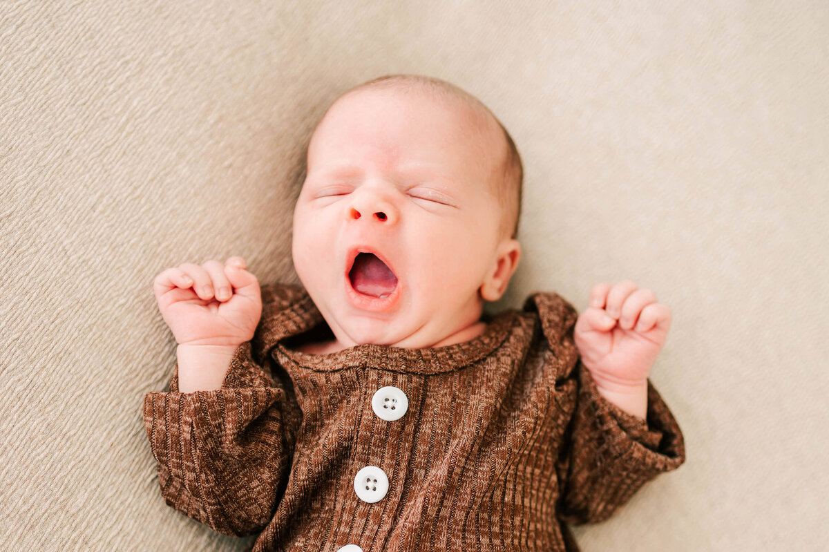 newborn photo in Springfield MO of boy yawning in bed