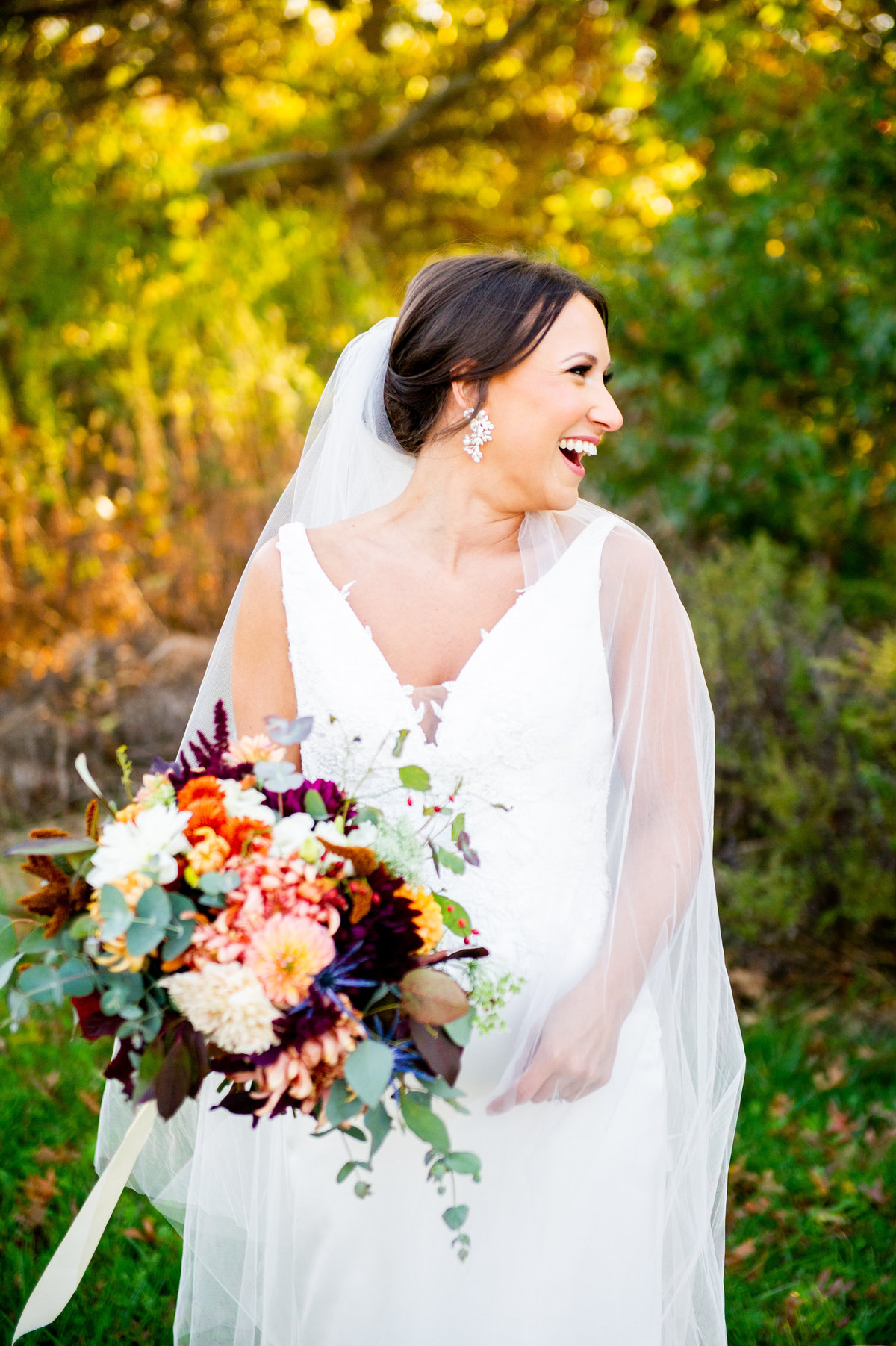 fall bride looks to side and laughs