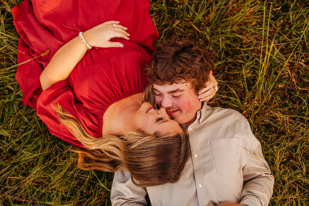 photo of man and woman laying in a field