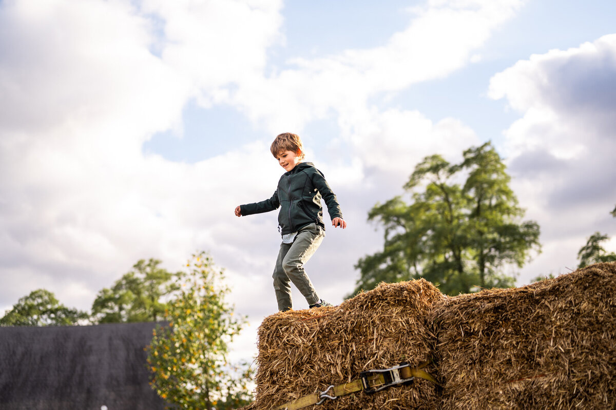 Boy playing on hay bales