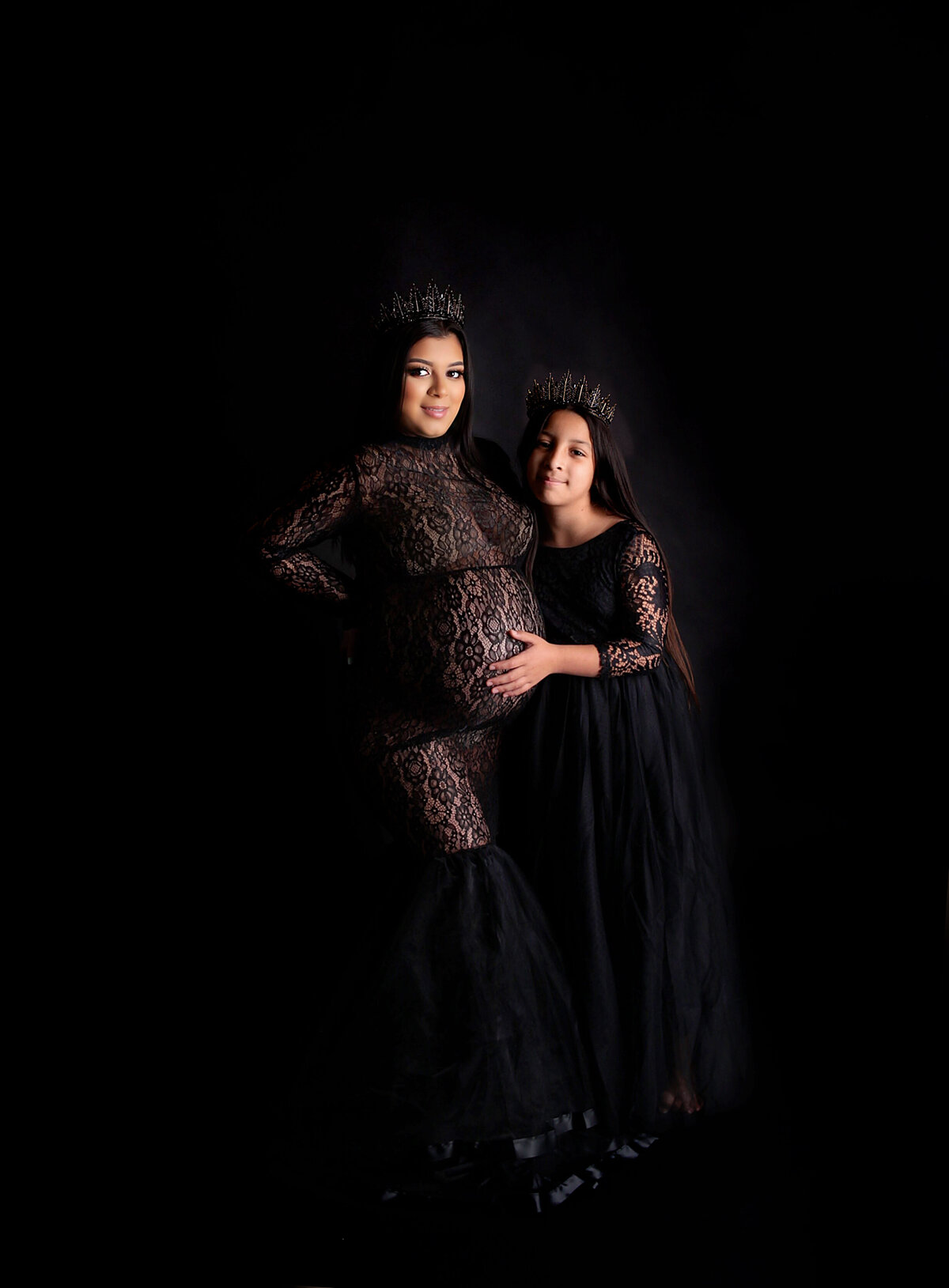 Mother and daughter wearing back gowns and goddess crowns during maternity photoshoot in Mount Juliet tennessee photography studio