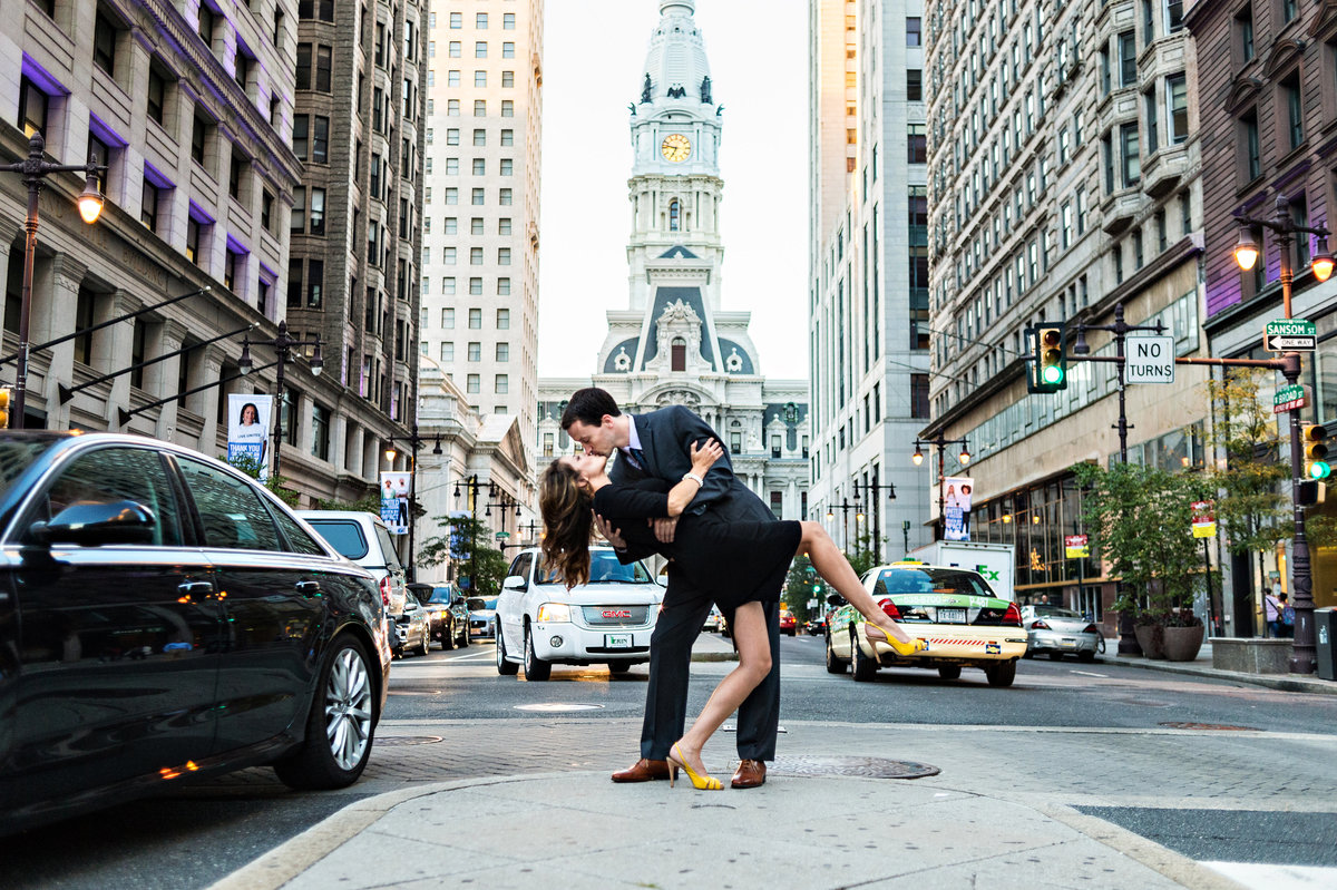 A man dips his bride to be in the middle of broad street in philadelphia.