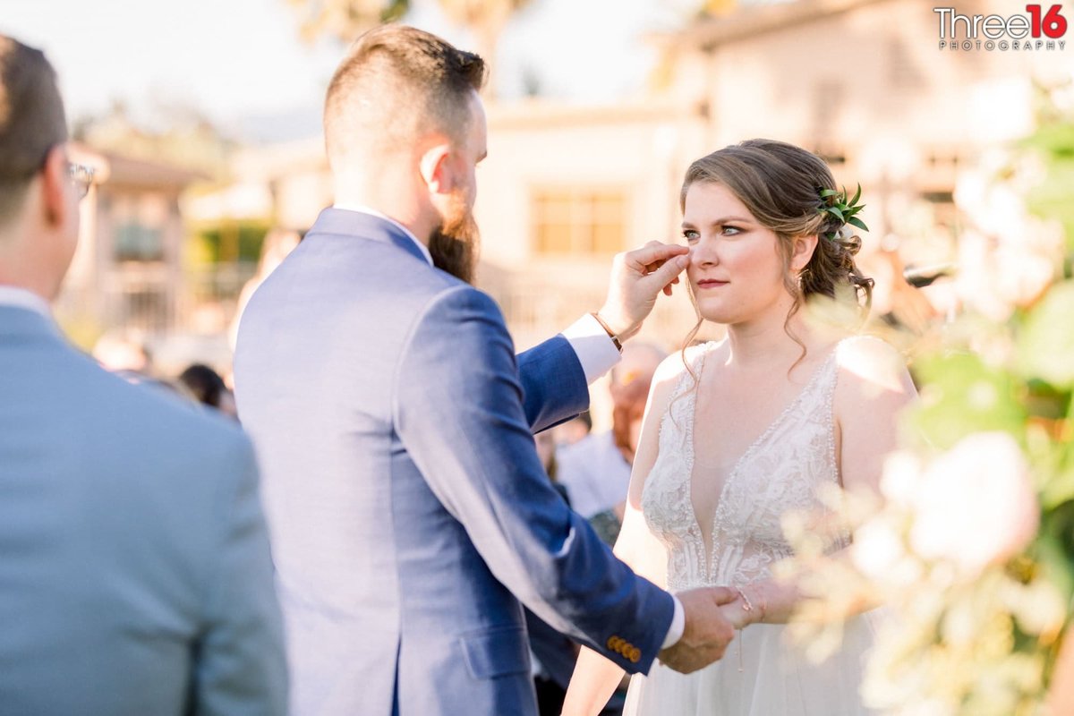 Groom wipes a tear from his Bride's face during the ceremony