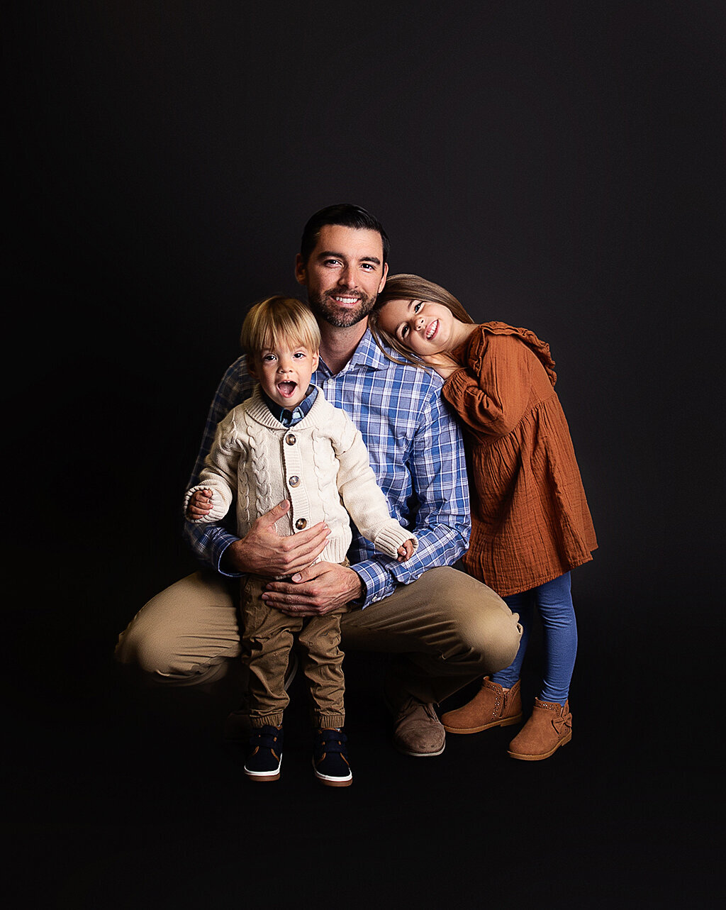 A father with his 2 young children during family photoshoot in Brentwood Tennessee photography studio