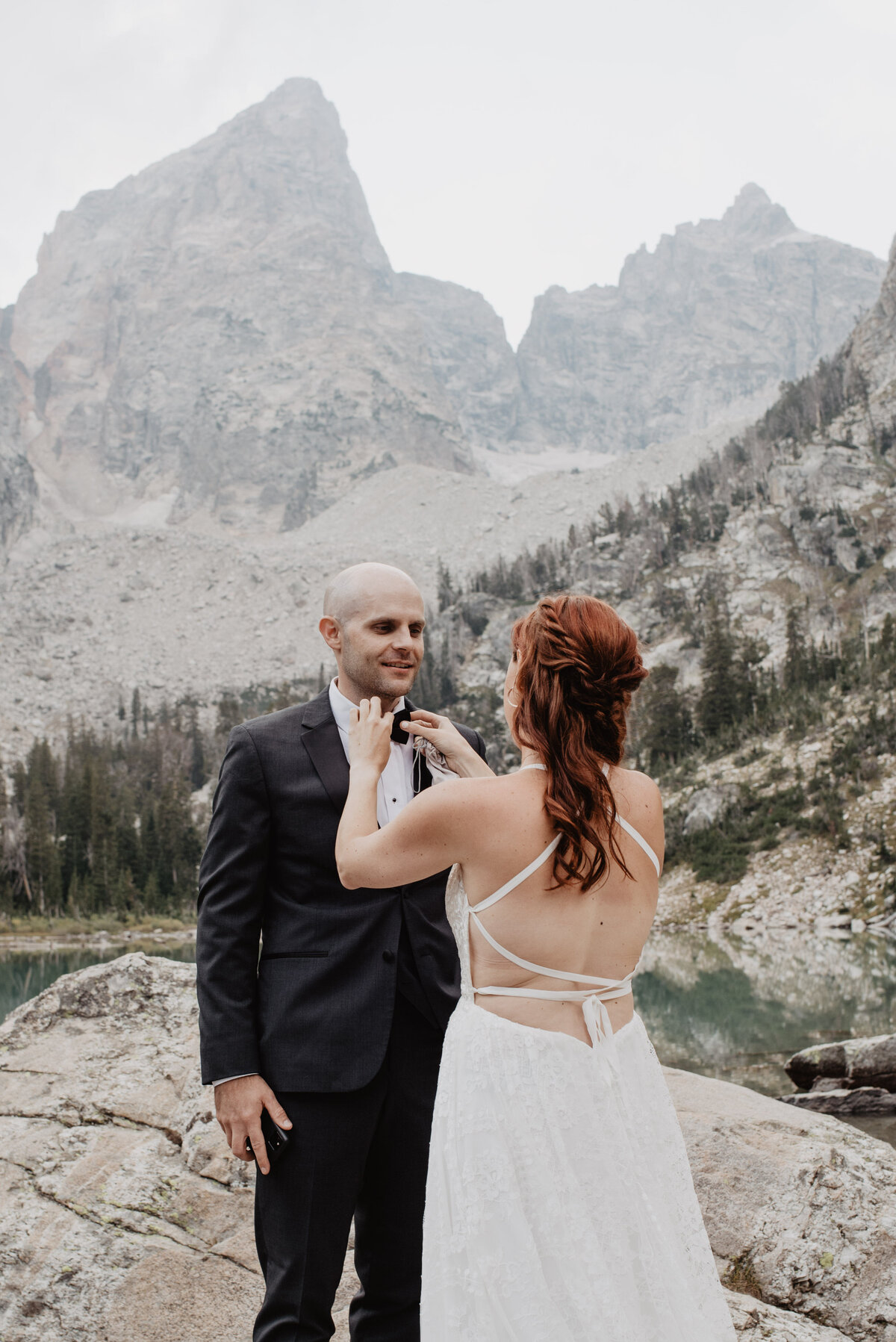 Jackson Hole photographers capture bride helping groom get ready for elopement