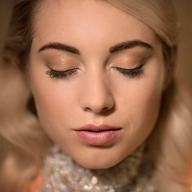 The close-up view of a woman wearing face makeup.