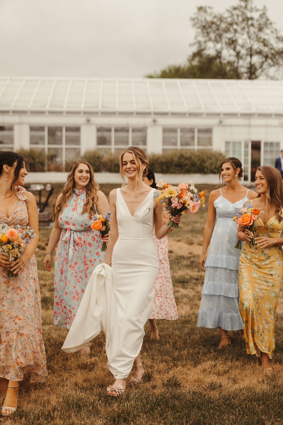 bride and bridesmaids walking at audreys farmhouse wedding venue