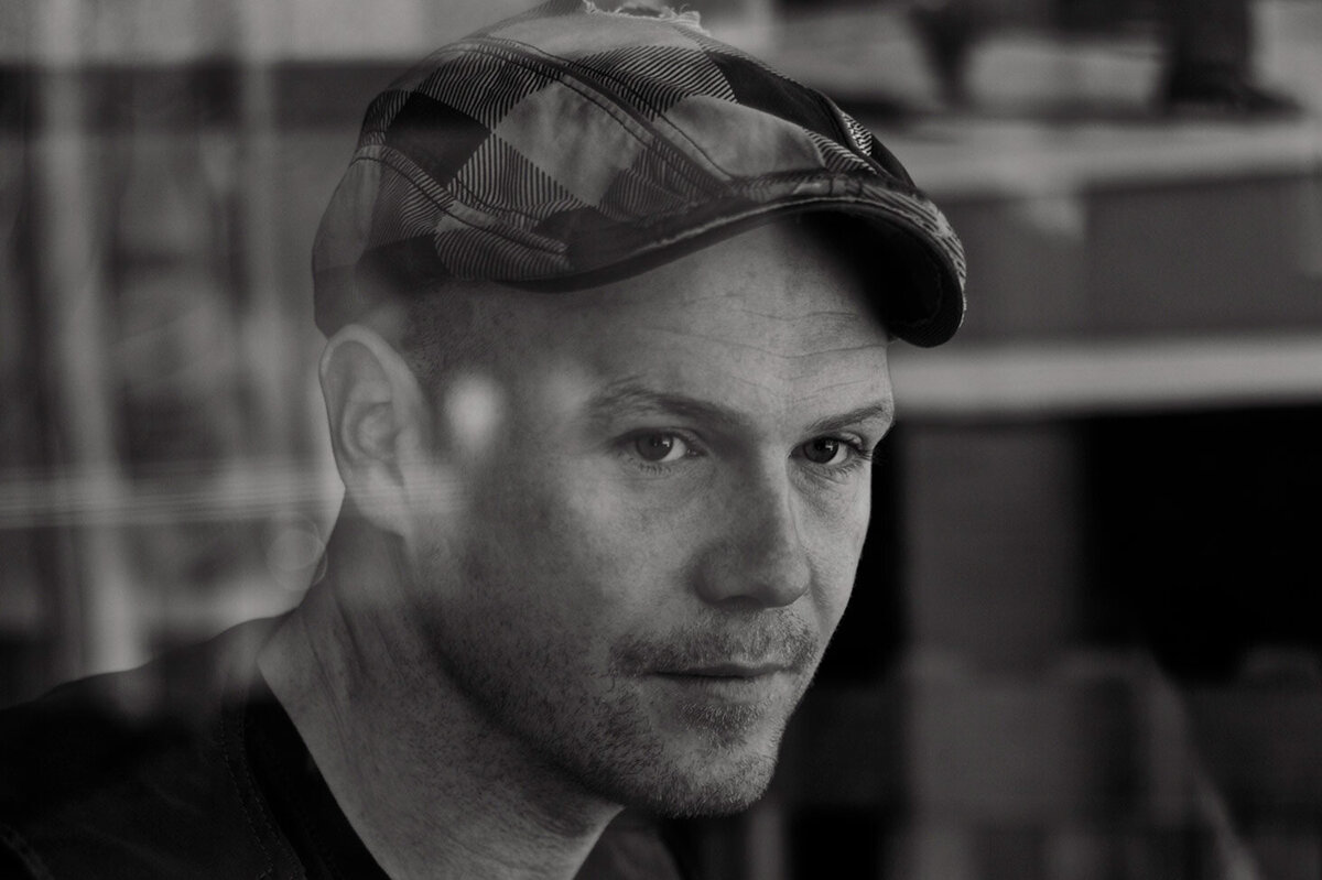 Male musician portrait Ben Crosby  black and white close up behind reflections  on window