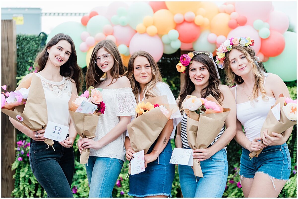 Girls posing with their paper flower bundles