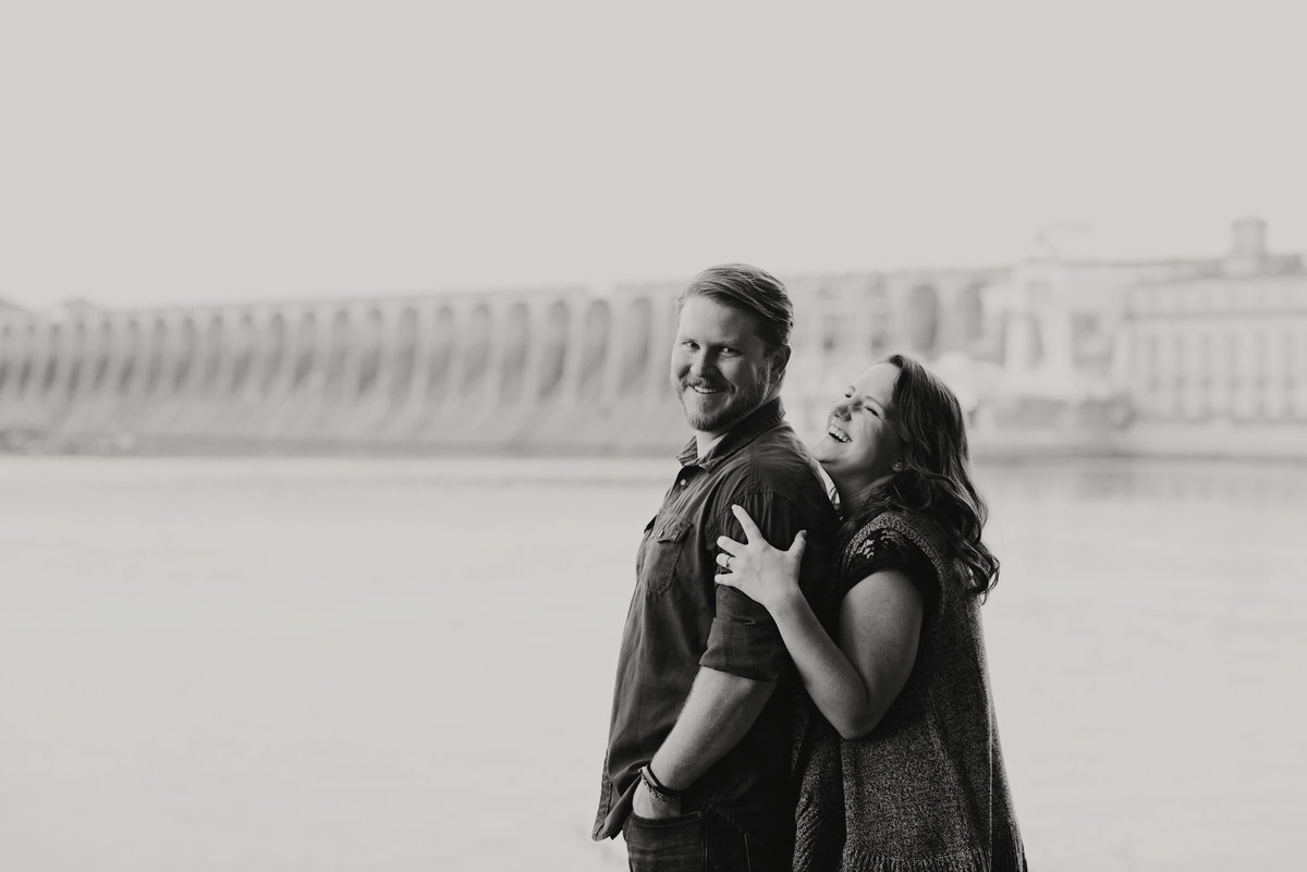 Couple cuddling and laughing  at wheeler dam engagement session