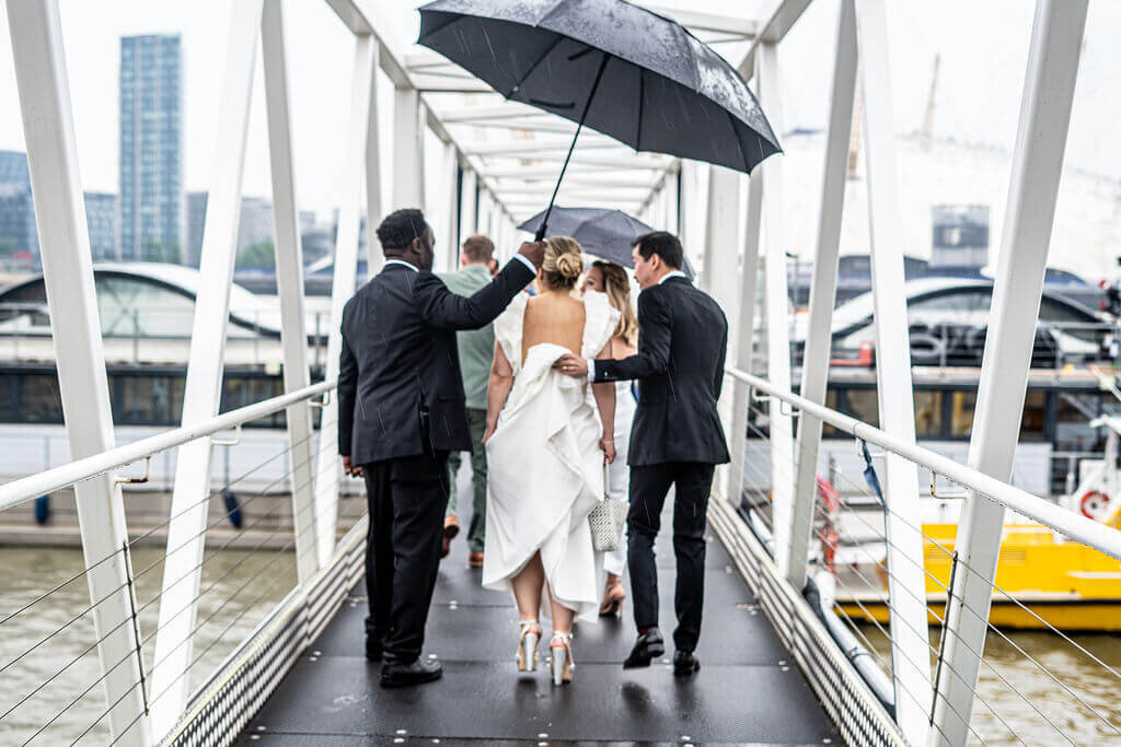 Trinity Buoy Wharf bride and groom are crossing bride to river boat