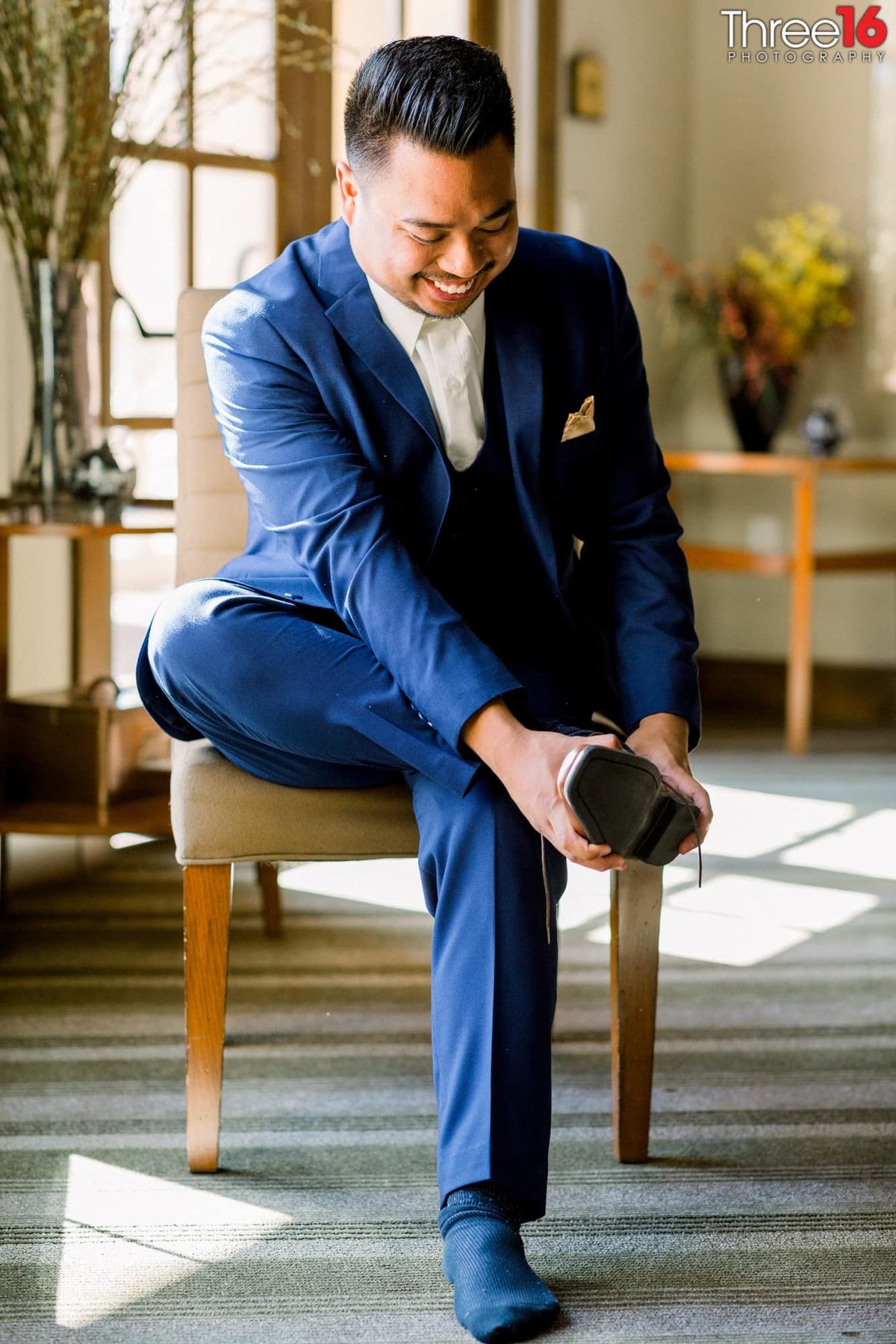 Groom putting on his shoes before the ceremony starts
