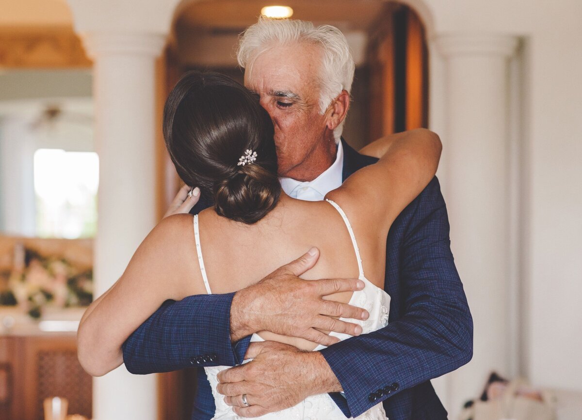 Father hugging bride after seeing her for the first time at wedding in Riviera Maya