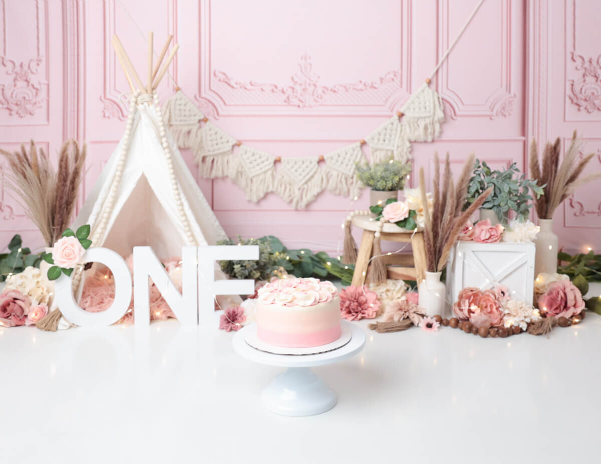 Beautifully styled boho cake smash scene with a decorated cake and playful props in Rochester, NY.
