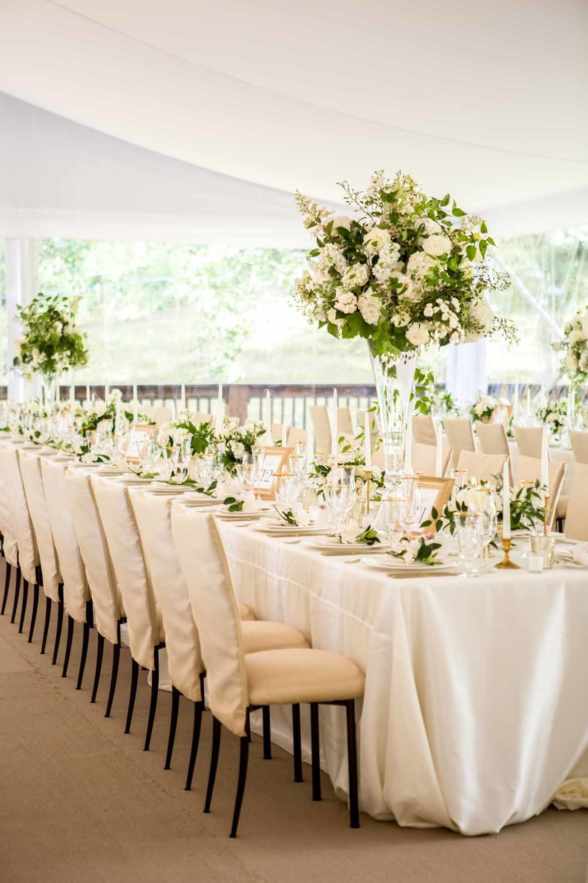White summer tent wedding reception with white and green floral