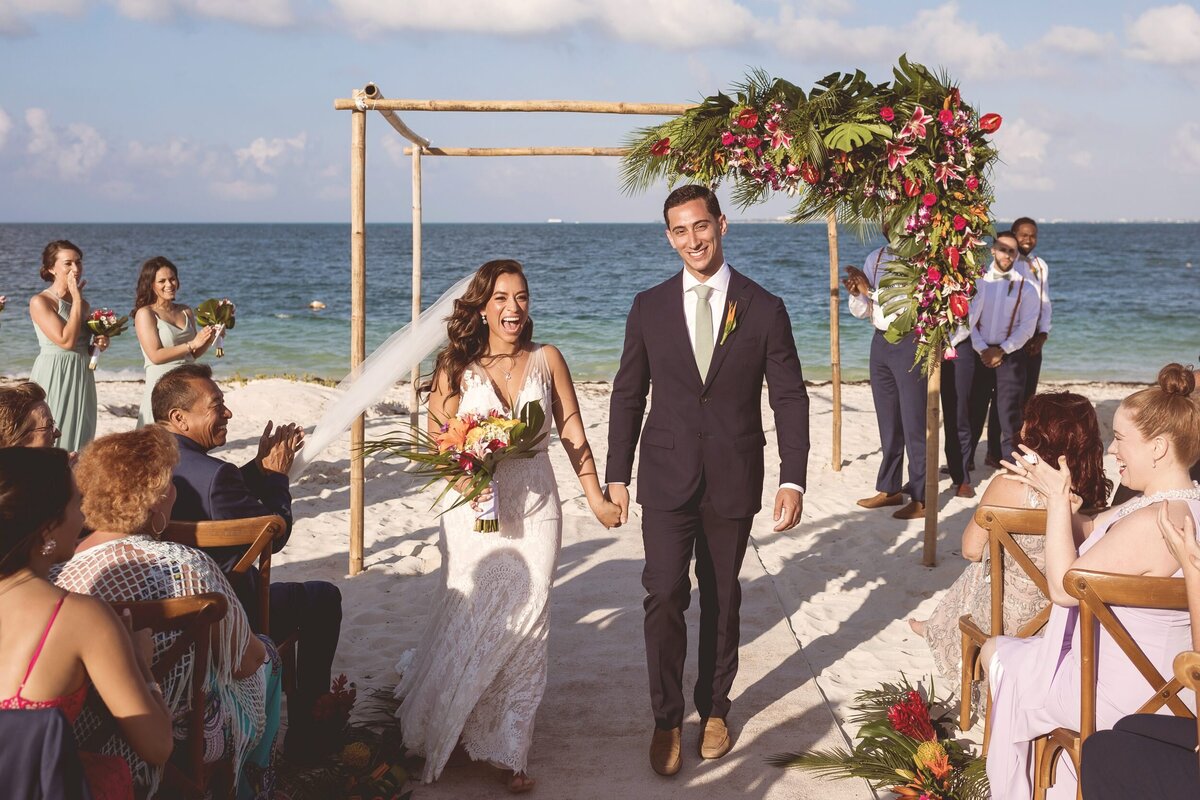 Bride and groom celebrate after being married at wedding in Cancun