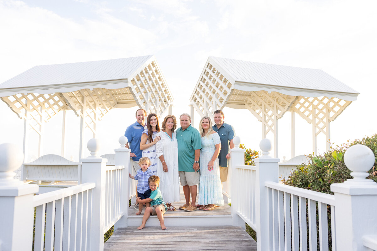 A family standing on a wooden pier smiling together