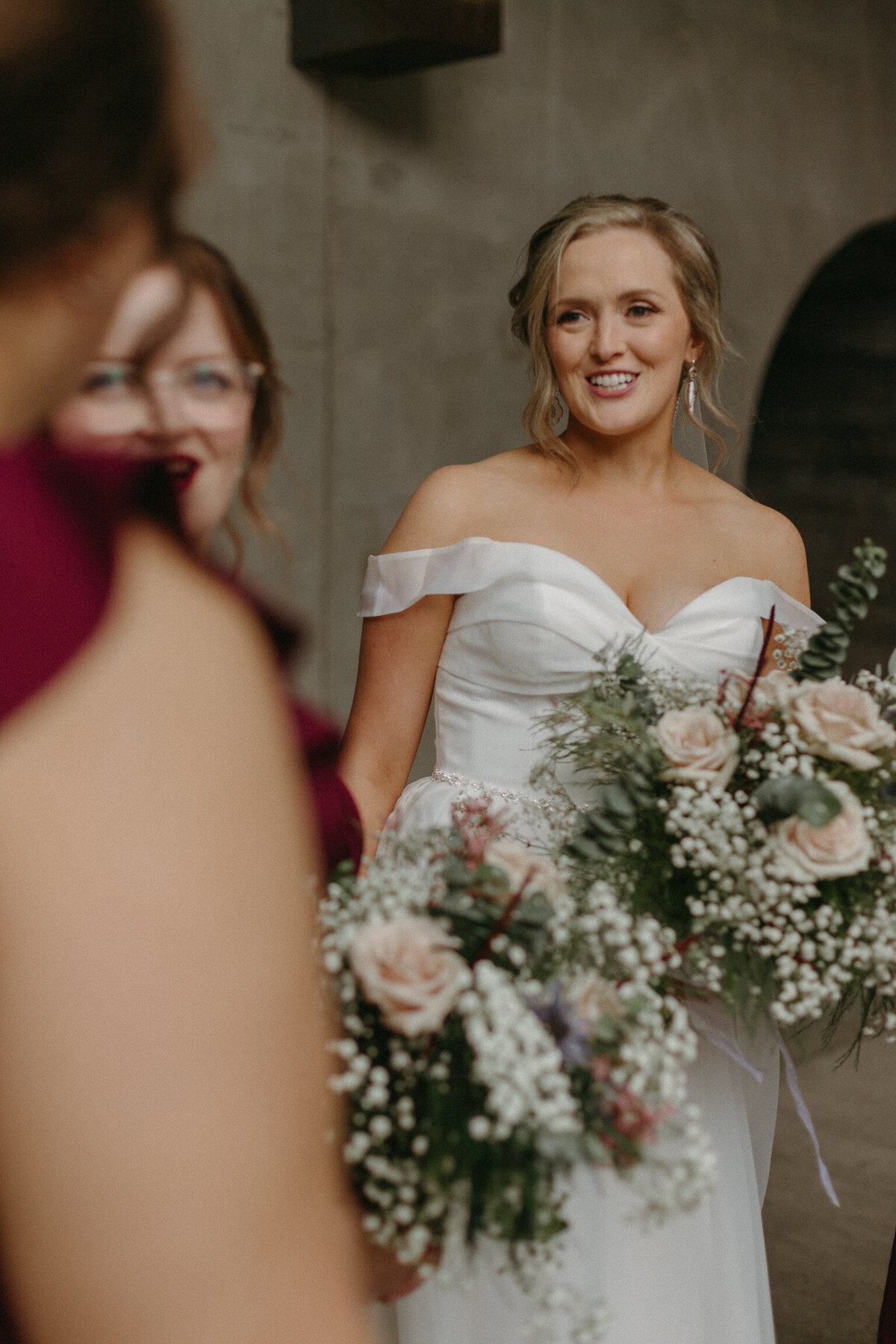 Bride laughs with bridesmaids during wedding photos downtown Ottawa
