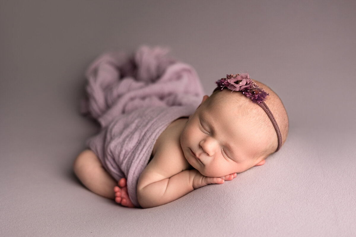 best-columbus-ohio-newborn-photographer-near-me-grove-city-hilliard-dayton-beavercreek-tipp-city-troy-bellbrook-centerville-kettering-london-springfield-baby-girl-in-purple-wrap-and-headband