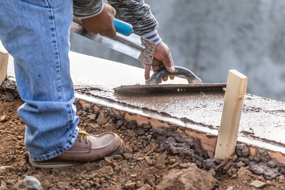 construction-worker-using-wood-trowel-on-wet-cemen-2024-09-11-19-50-49-utc