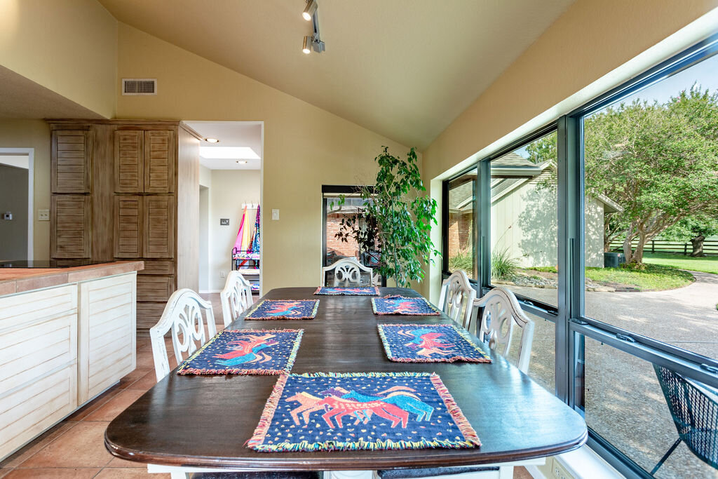 Dining room with dining table for six and a beautiful view of the pool in this 5-bedroom, 4-bathroom vacation rental house for 16+ guests with pool, free wifi, guesthouse and game room just 20 minutes away from downtown Waco, TX.