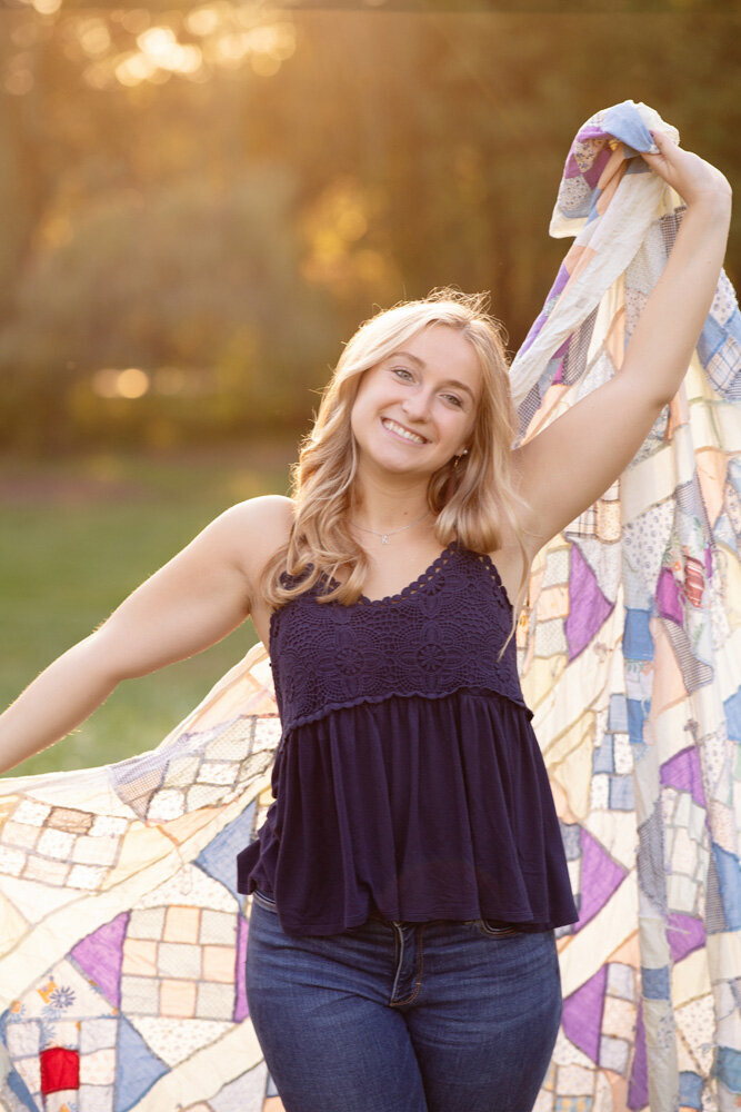 Senior session of young woman holding up a sweater