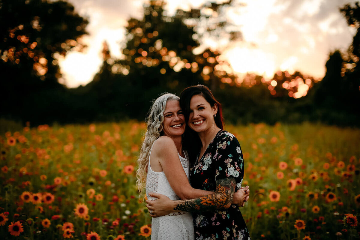 mother and daughter holding each other in a flower field