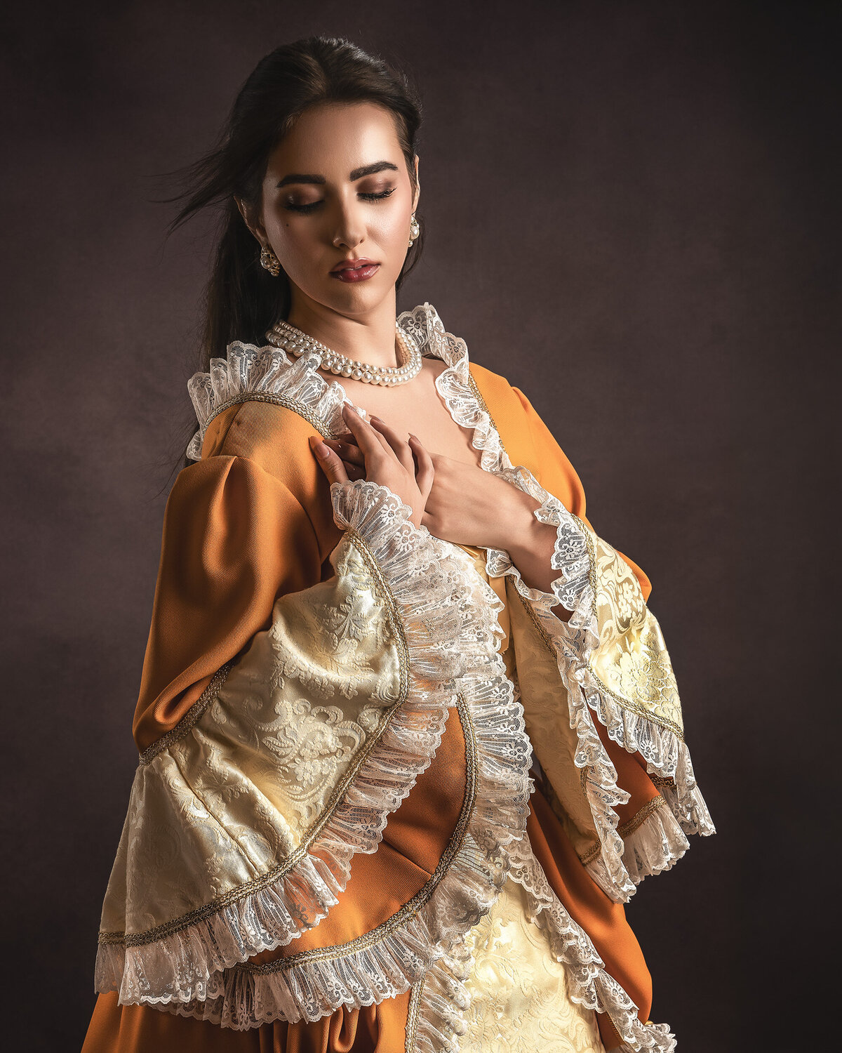 Elegant woman in vintage-inspired burnt orange gown with lace details and pearl jewelry, fine art portrait photography by AMM Fine Art Studio, Kirkland .Washington